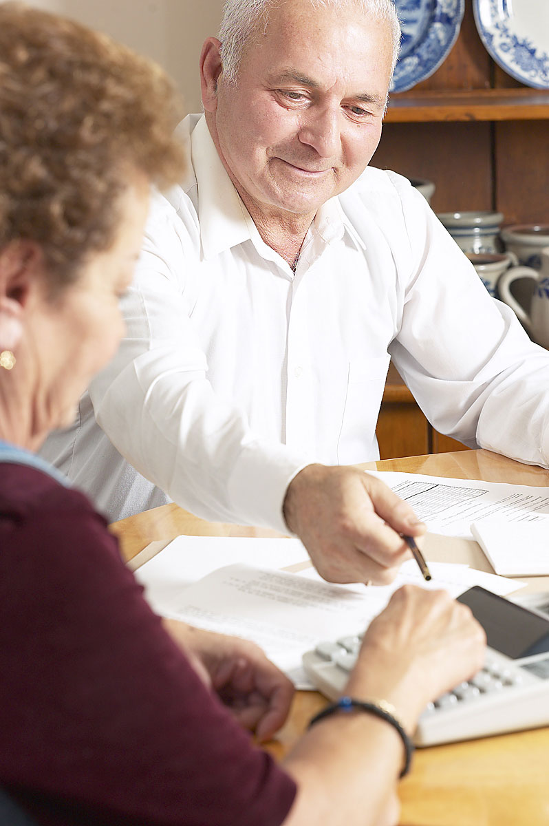 Two Older Adults Preparing Finances at a Table